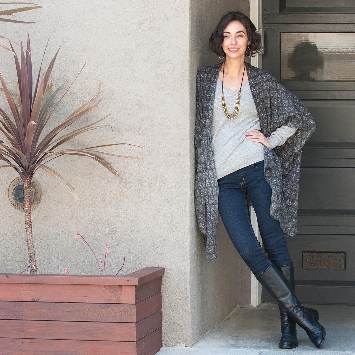 woman wearing a grey printed kimono cardigan with jeans and black boots